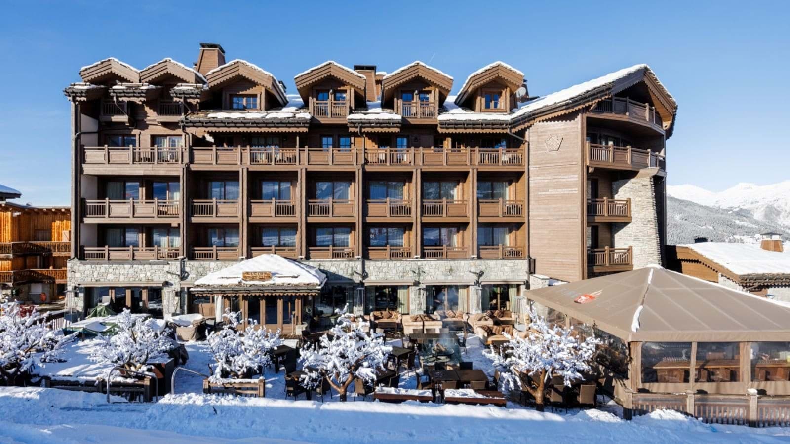 Ski-in/ski-out lodge exterior with heated après-ski terrace and fire pits