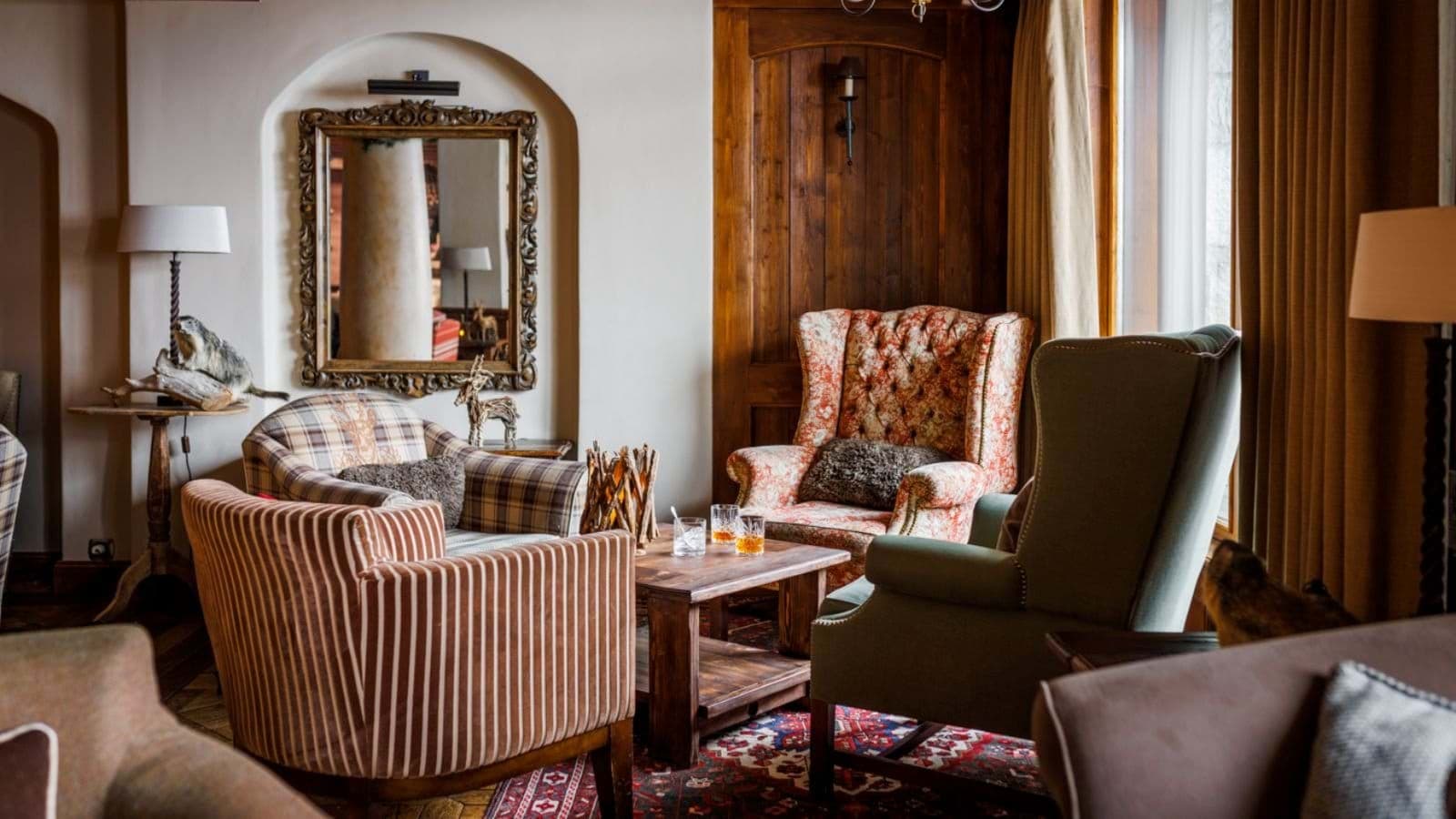 Lounge seating area with wingback chairs and rustic wood-paneled walls