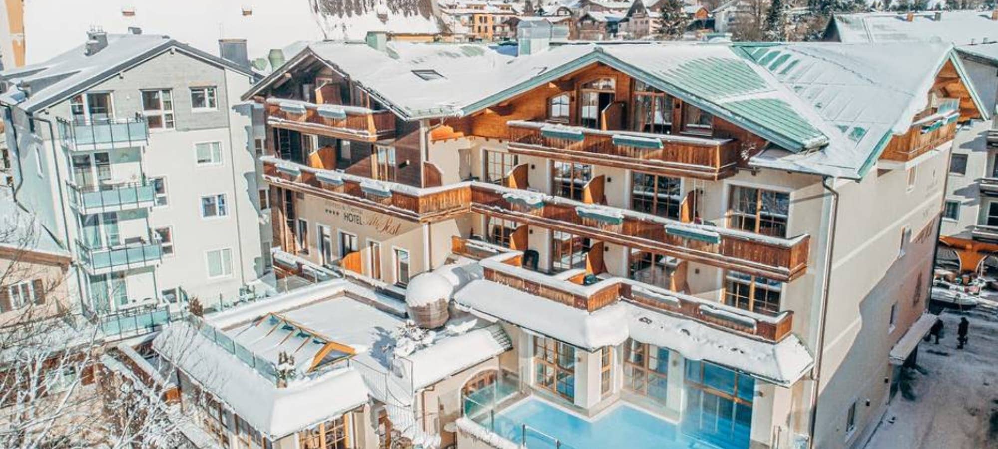 Chalet exterior featuring heated outdoor pool and private balconies
