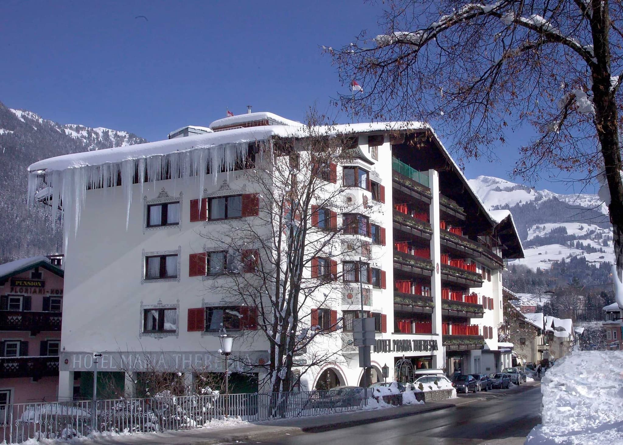Hotel exterior with private balconies and street-level parking in Kitzbühel