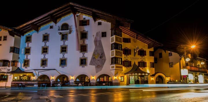 Chalet exterior at night with street-level arcade and hand-painted facade murals