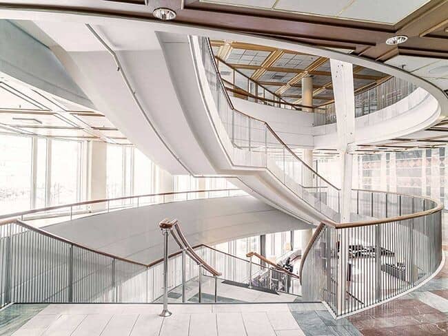 Atrium featuring multi-level curved staircase and glass railings