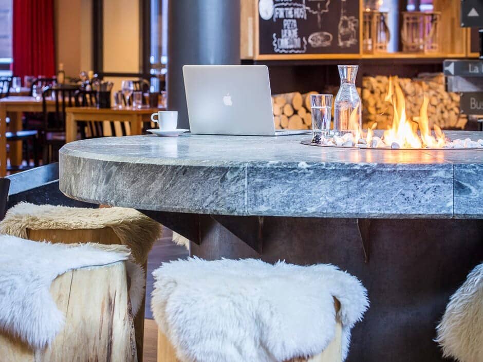 Shared lounge featuring marble fire pit table and log seating