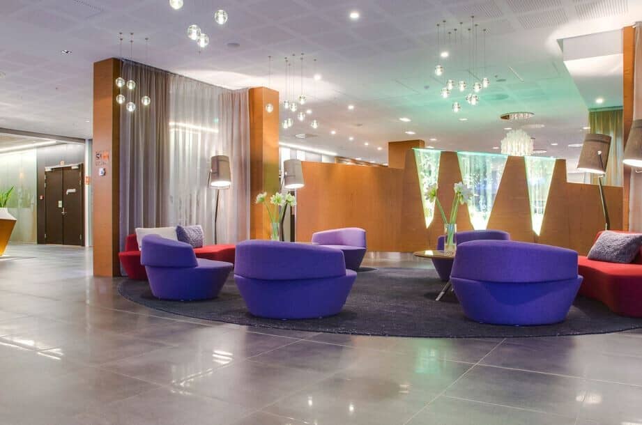 Shared lobby lounge with swivel armchairs and ambient pendant lighting