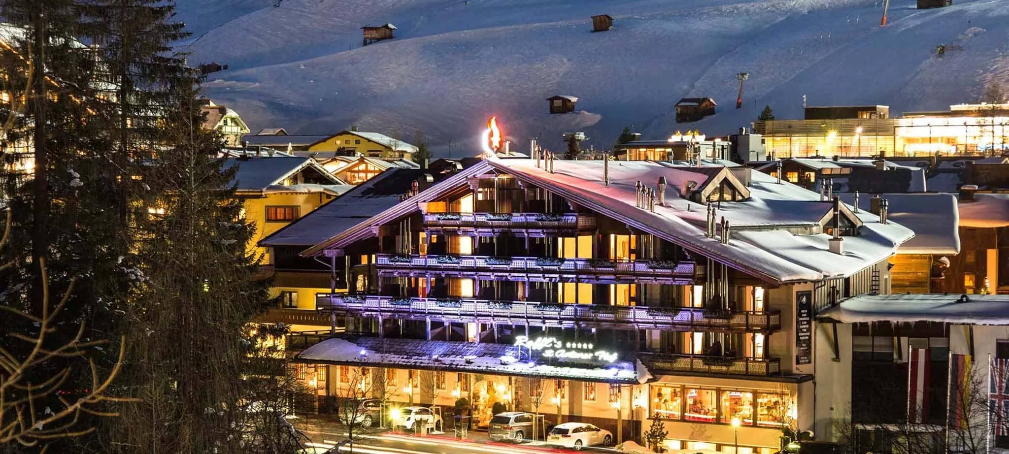Chalet exterior at night with private balconies and ski-in access
