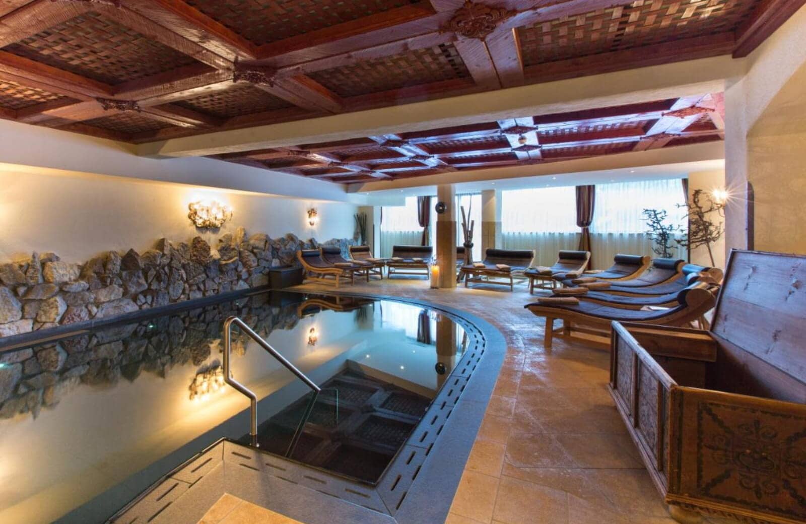Indoor pool with carved wood ceiling and lounge seating for 10