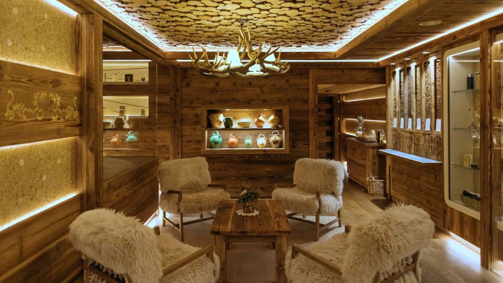 Lounge area featuring antler chandelier, wood-stack ceiling, and seating for four