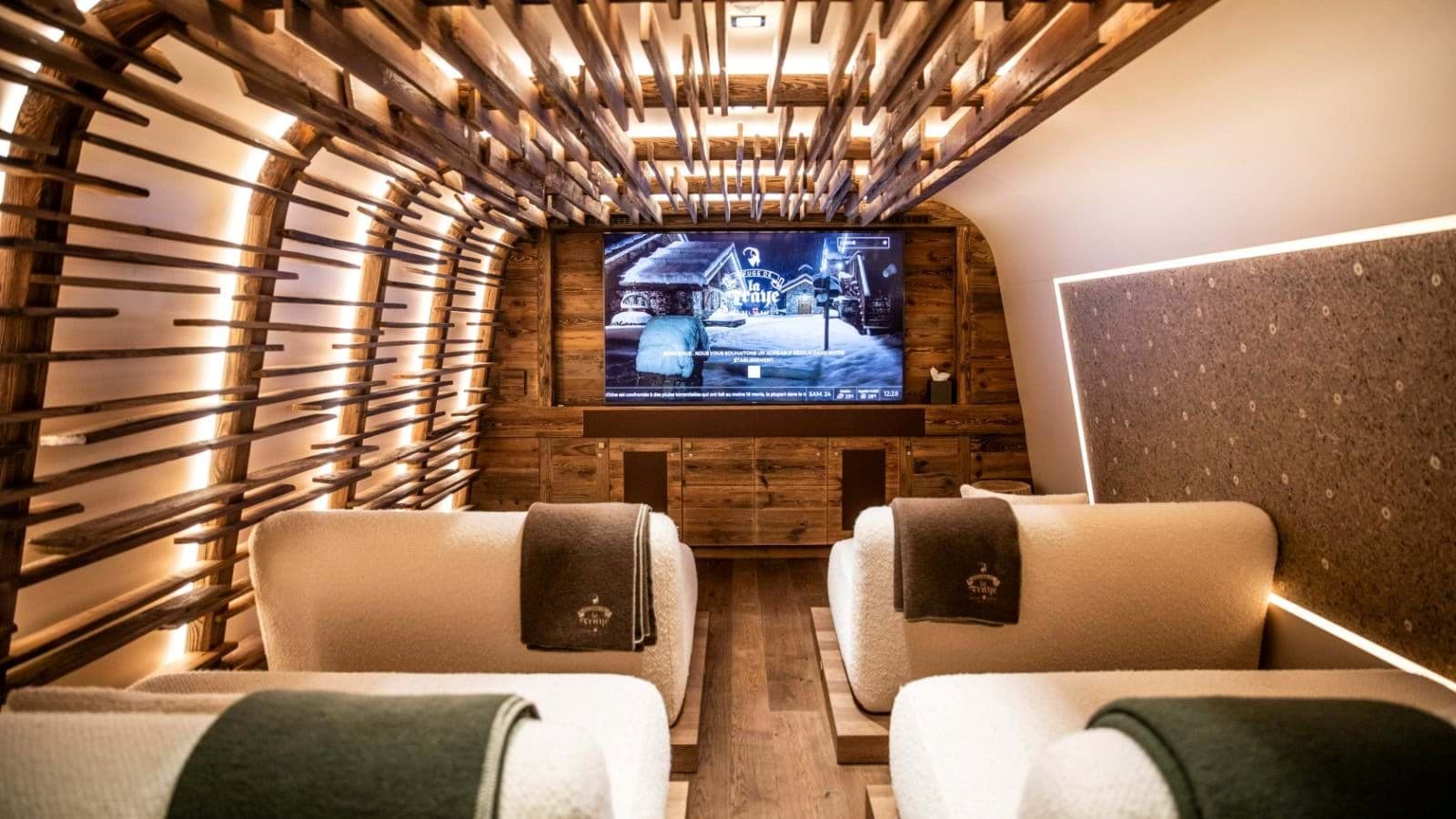 Private cinema room with lounge seating and backlit wood slat ceiling