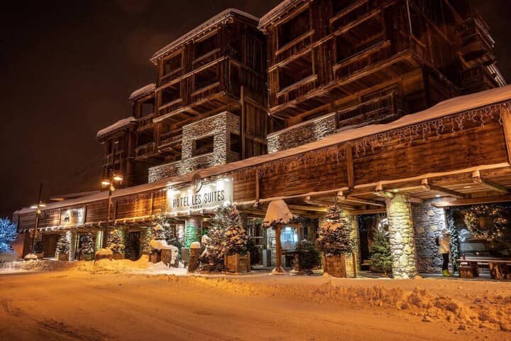 Ski-in ski-out lodge entrance with timber balconies and stone pillars