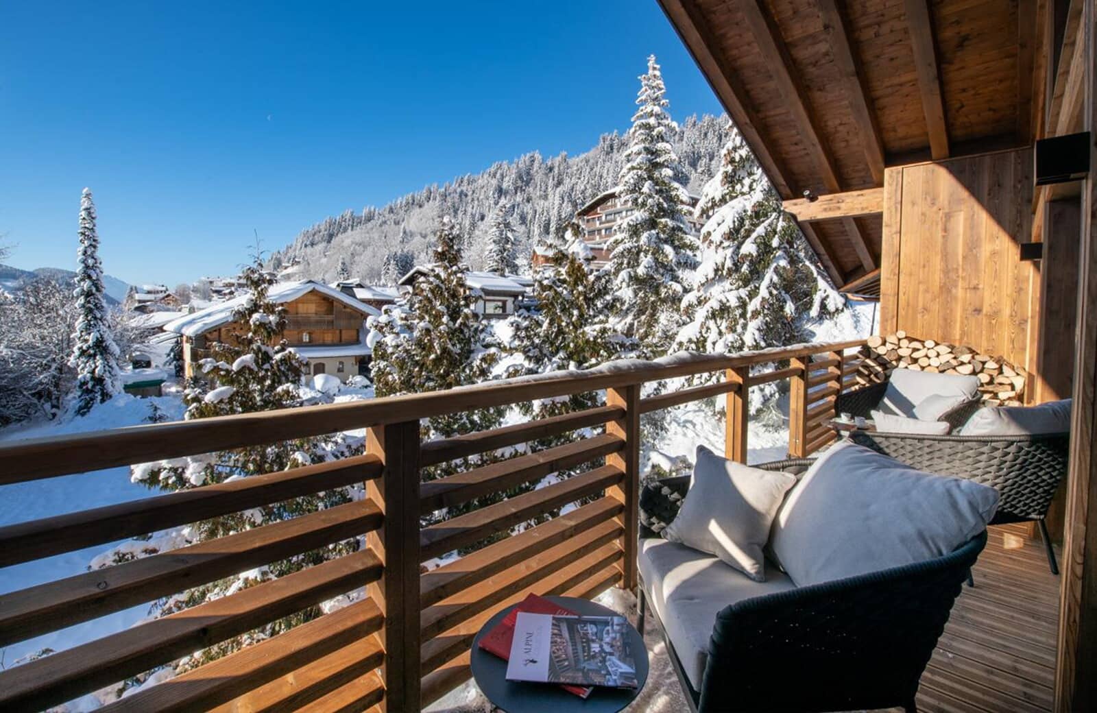 Covered balcony with seating and firewood storage; mountain views