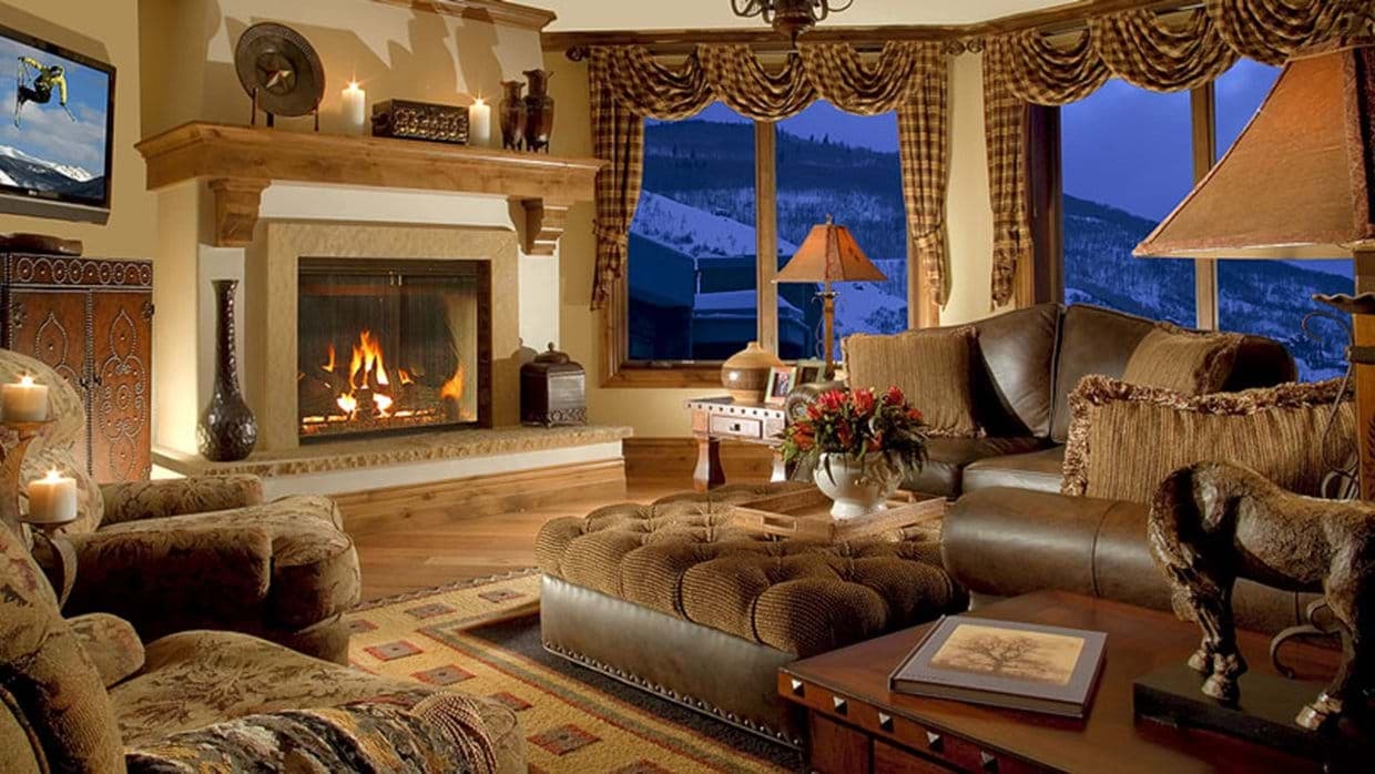 Living area with wood-burning fireplace and mountain-view bay windows