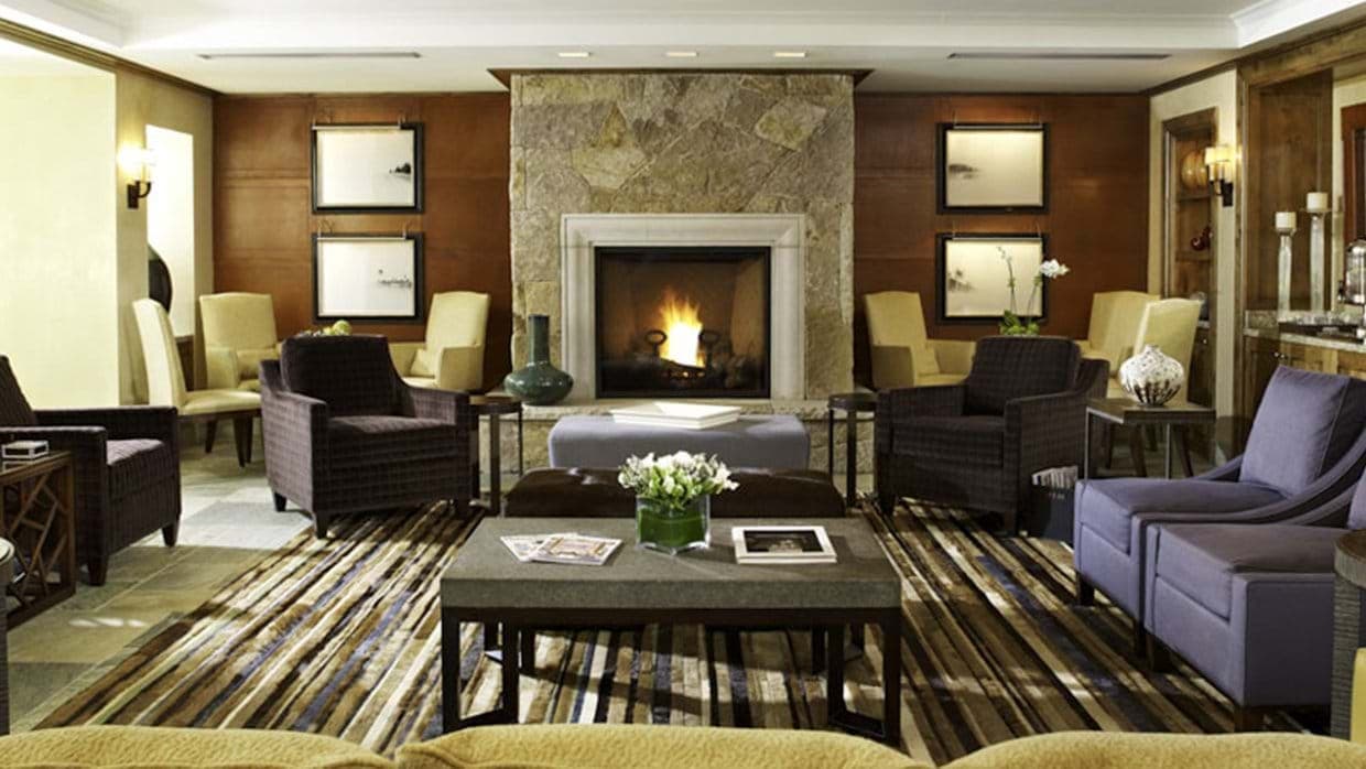 Living room with central stone fireplace and seating for 10