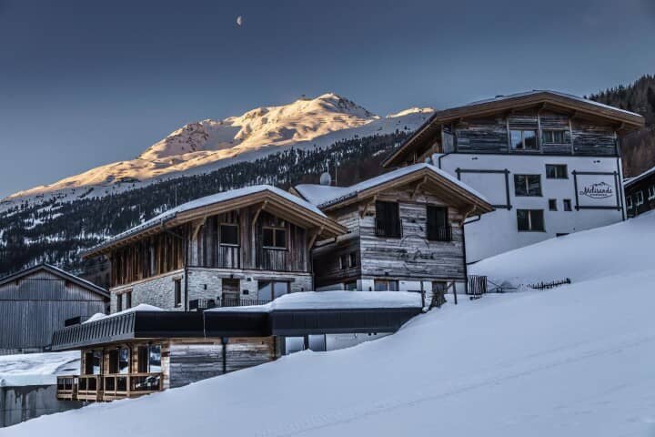 Chalet exterior with timber construction and mountain peak views