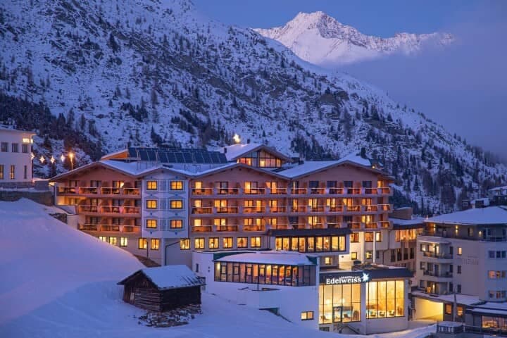Multi-story alpine lodge with private balconies and mountain backdrop