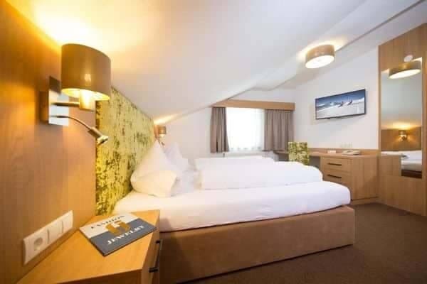 Bedroom with twin beds and built-in desk with wall-mounted TV