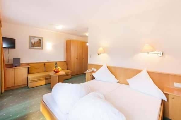 Studio layout with joined twin beds and sofa seating area