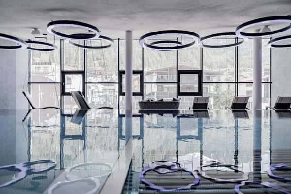 Indoor pool with floor-to-ceiling windows and hanging loungers