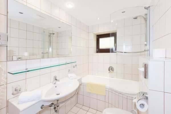 Bathroom with shower-tub combo and curved glass screen