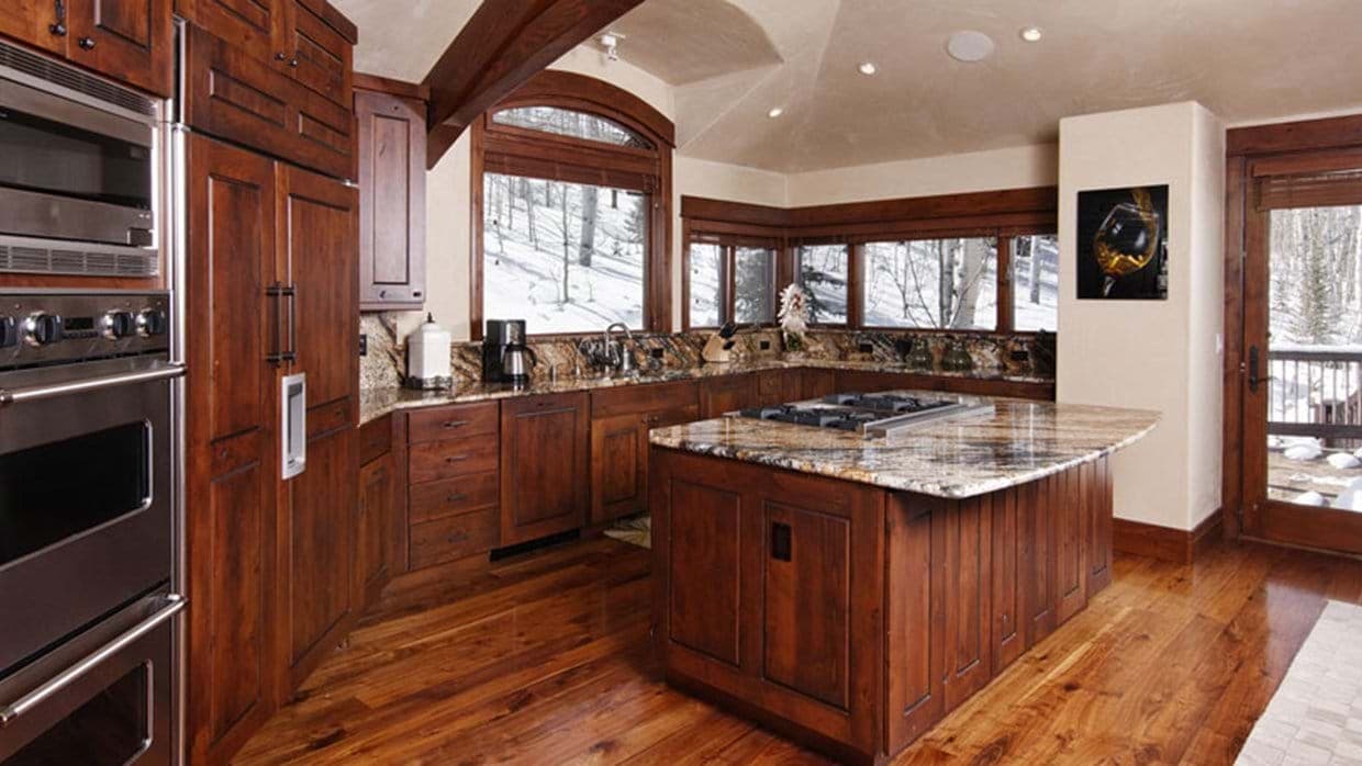 Kitchen with double wall ovens and gas cooktop island; mountain views