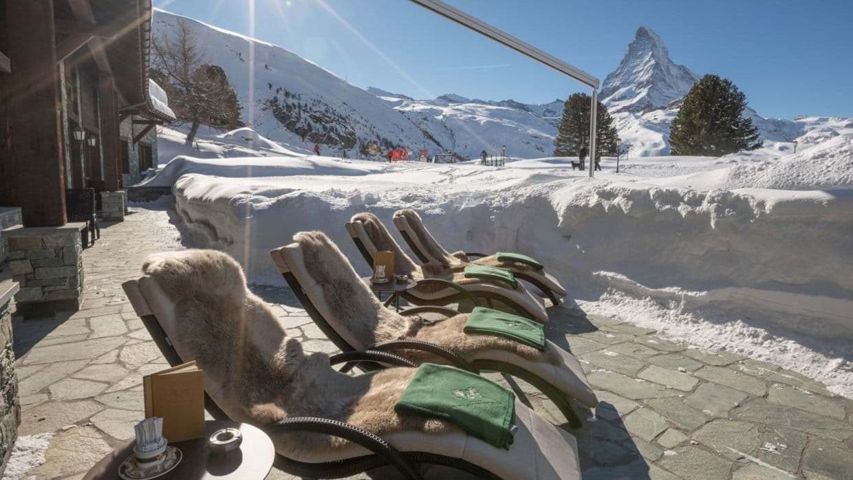 Stone patio with fur-lined loungers and Matterhorn peak views
