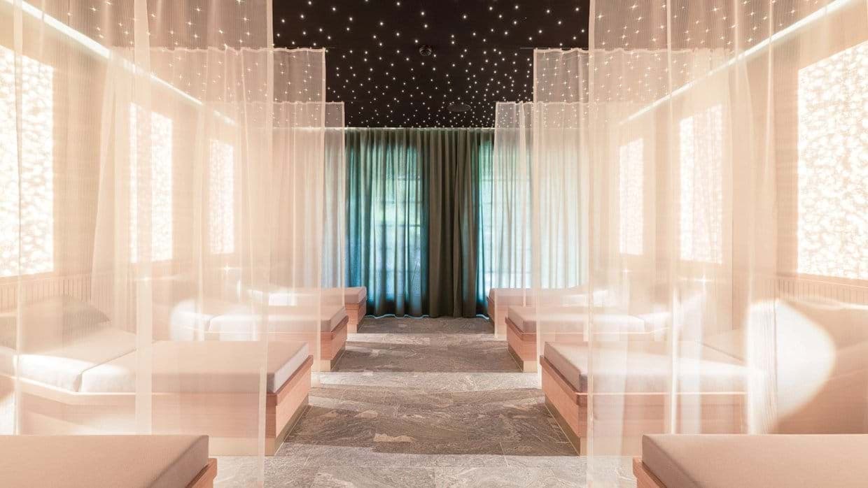 Spa relaxation room with daybeds, privacy curtains, and fiber optic starlight ceiling