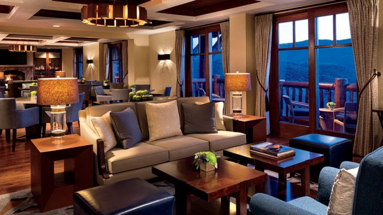 Lounge area with coffered ceilings and access to mountain-view balcony