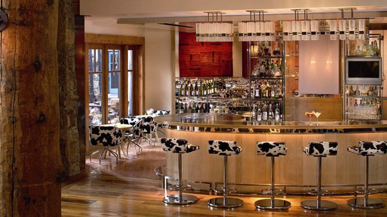 Indoor cocktail bar with cowhide stools and wine storage