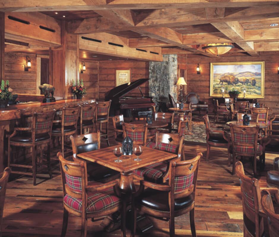 Lounge area with live-edge bar, baby grand piano, and table seating