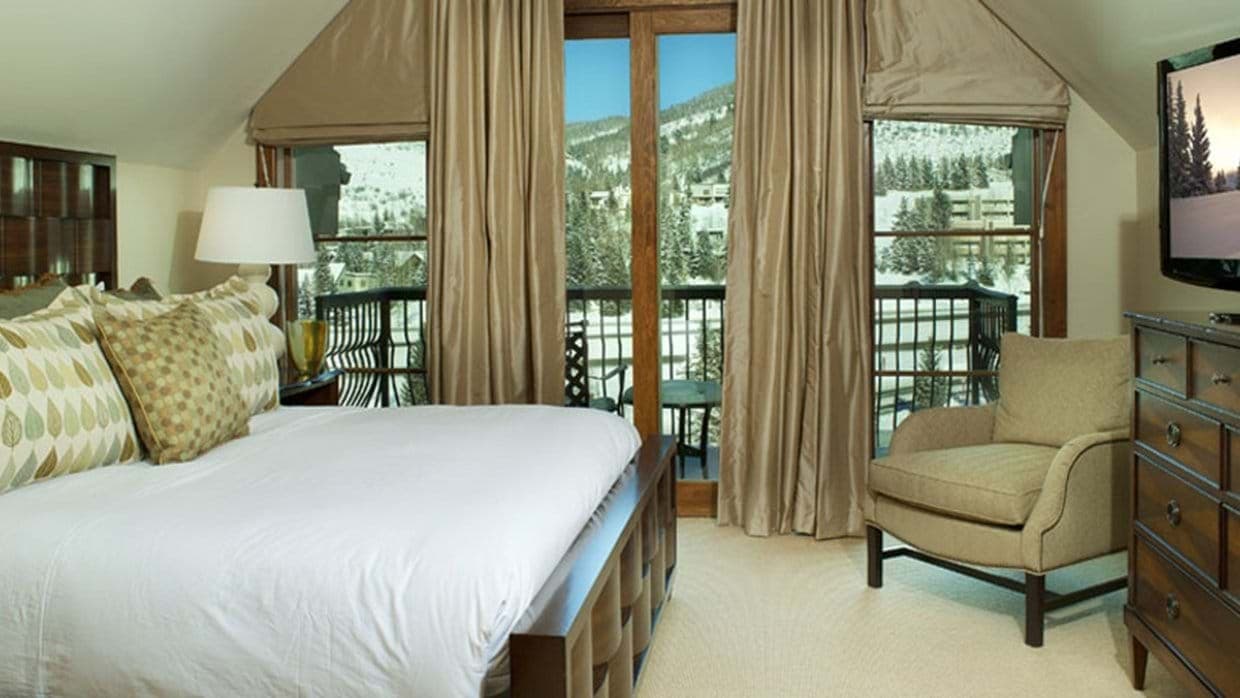 Bedroom with king bed and private balcony overlooking ski slopes