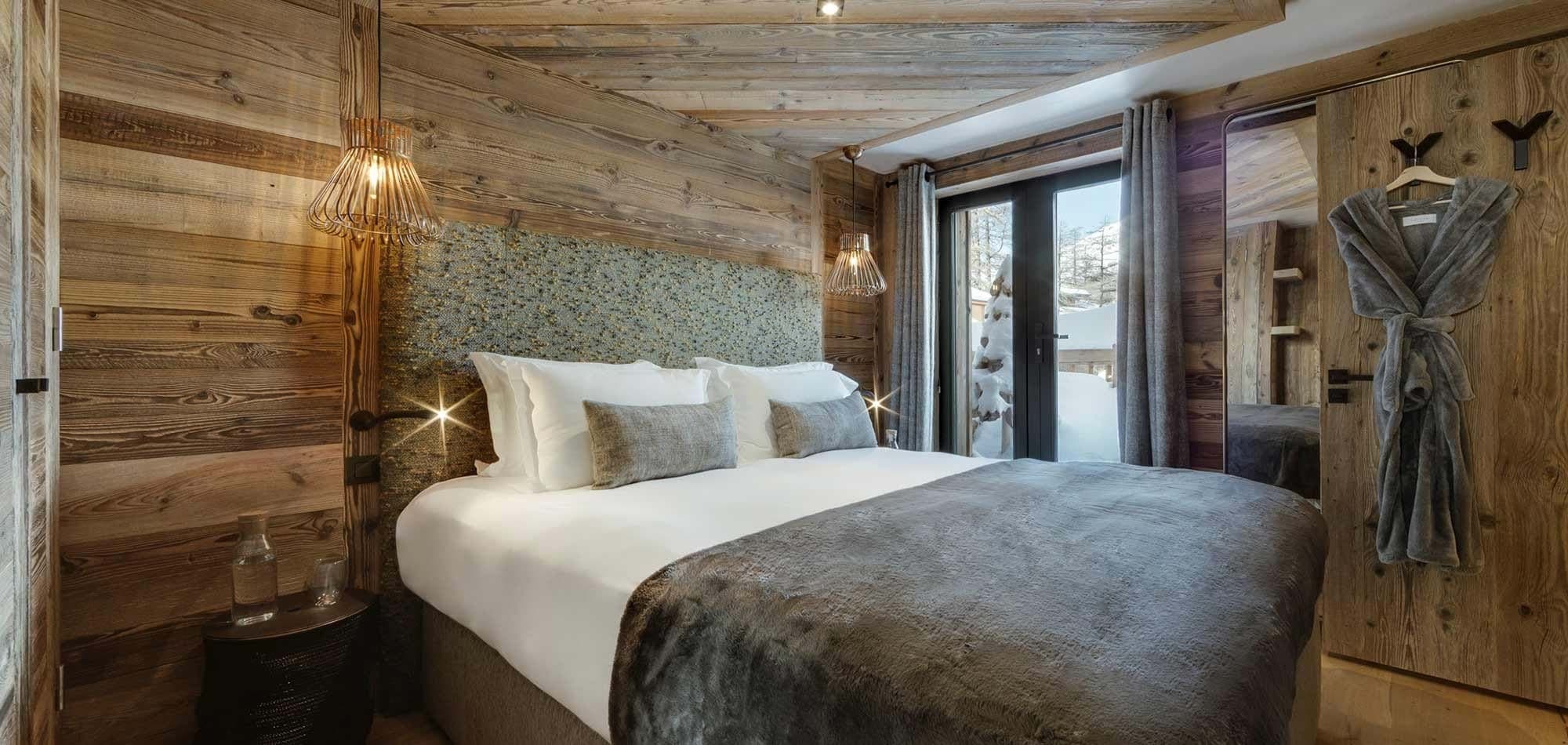 Guest bedroom with king bed and terrace access to snow views