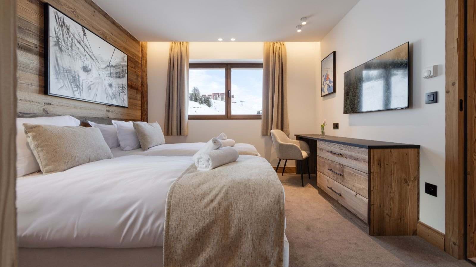 Guest bedroom with twin beds, dedicated workspace, and ski resort views