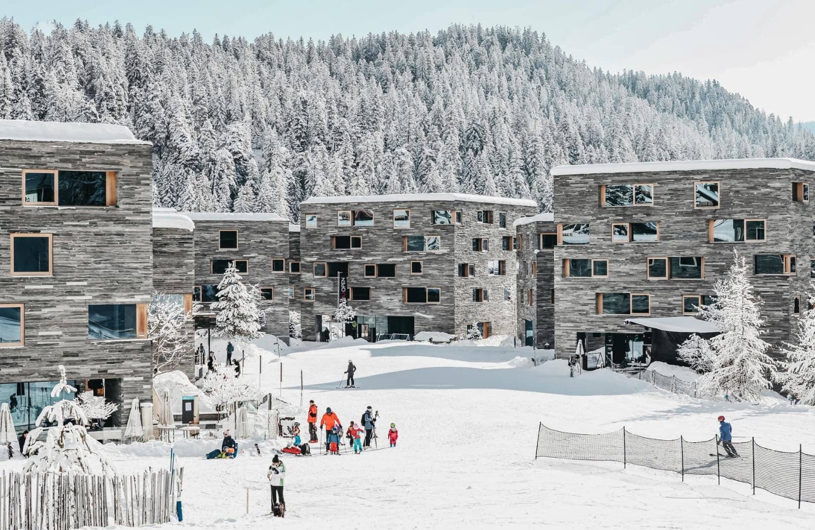 Ski-in/ski-out resort exterior with direct trail access and forest backdrop