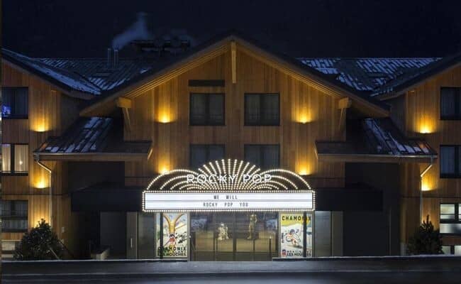 Chalet entrance at night with marquee lighting and wood siding
