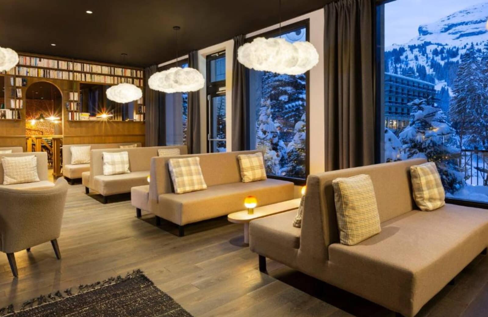 Lounge area with library wall and floor-to-ceiling mountain views