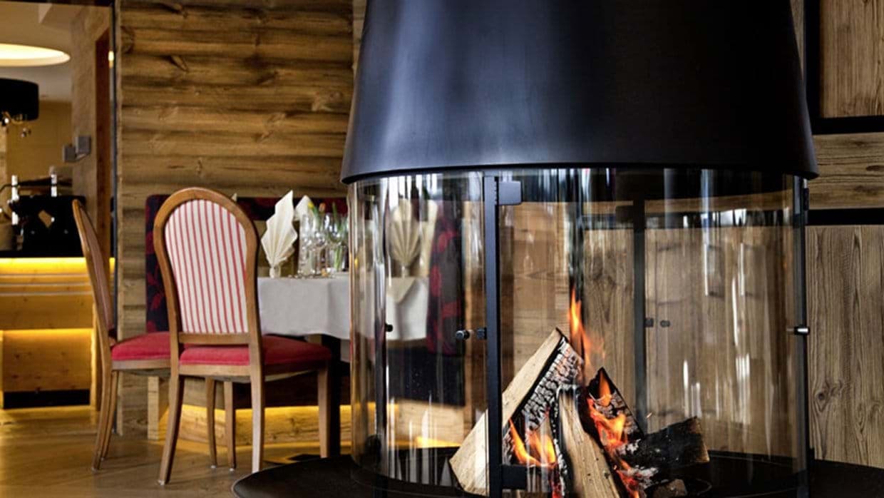 Dining area featuring central 360-degree glass wood-burning fireplace