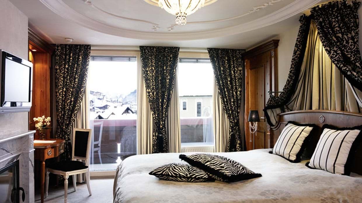 Primary bedroom with private balcony, desk, and mountain views