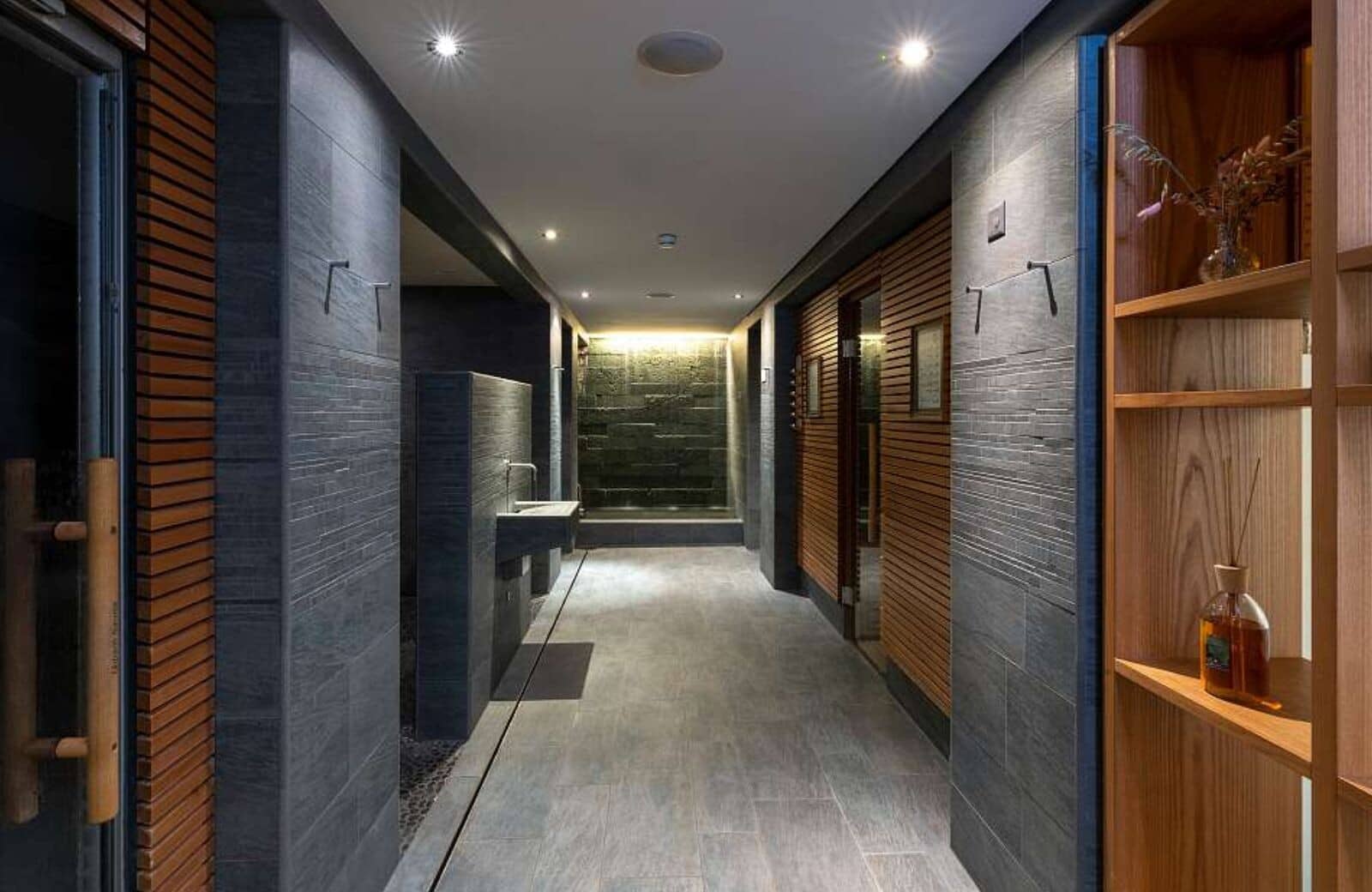 Spa hallway with heated stone floors and stone waterfall feature