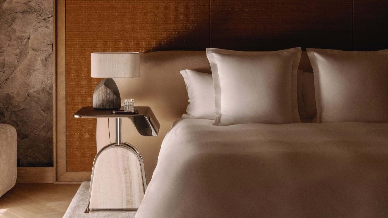 Bedroom featuring stone accent wall and bedside table with integrated lighting