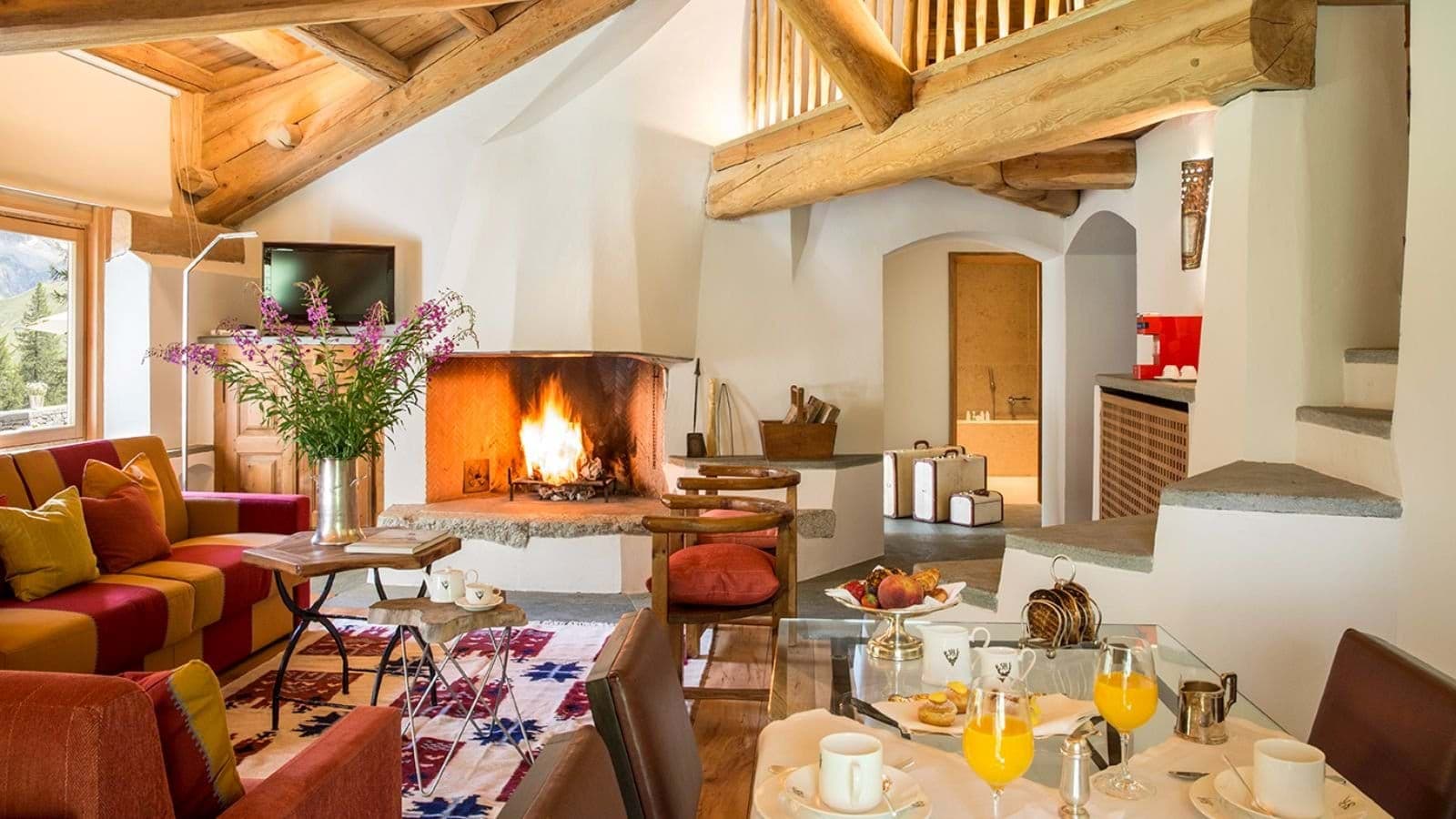 Open living area with wood-burning fireplace and exposed timber beams