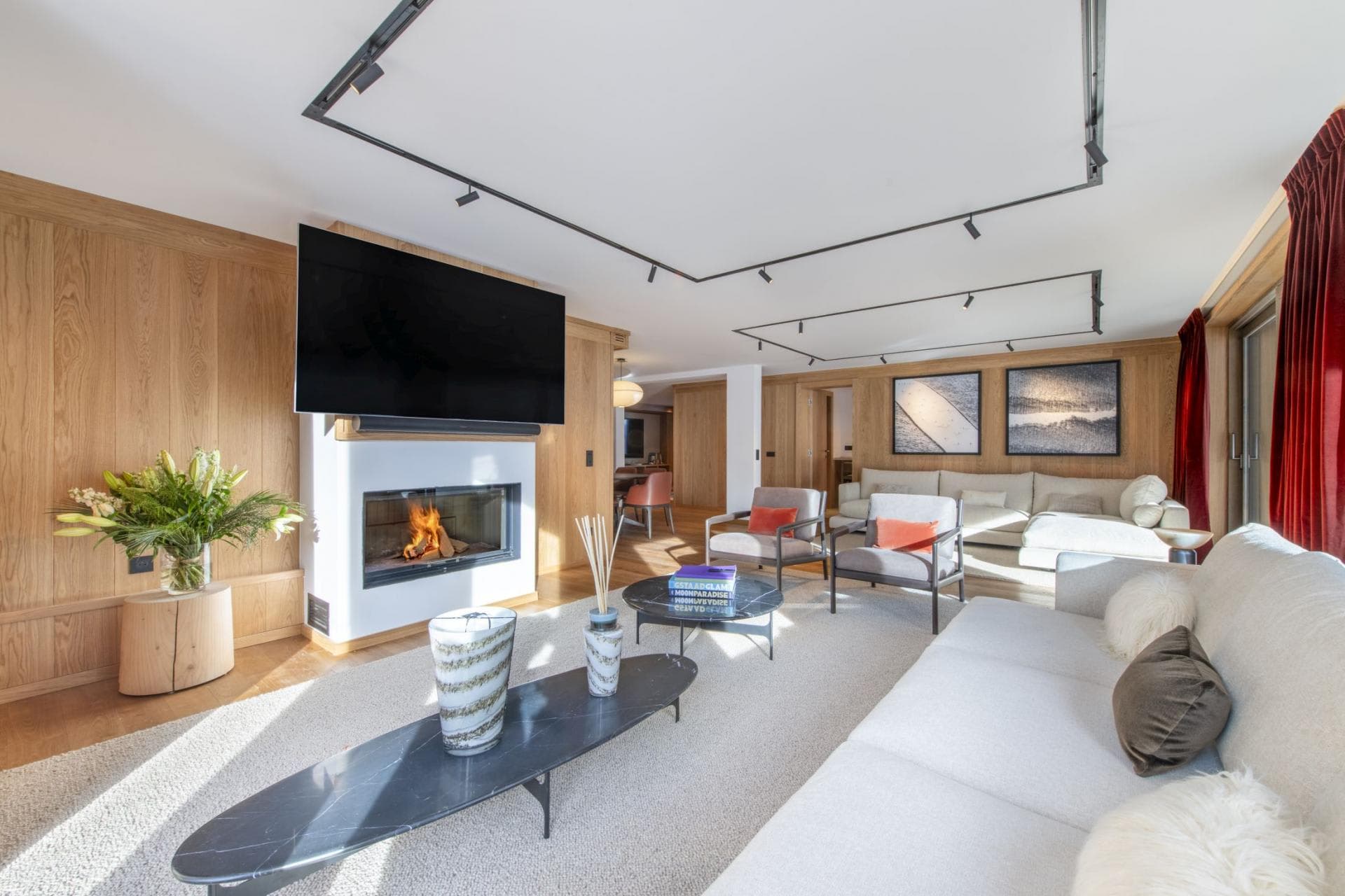 Living area with wood paneling, wood-burning fireplace, and 75-inch smart TV