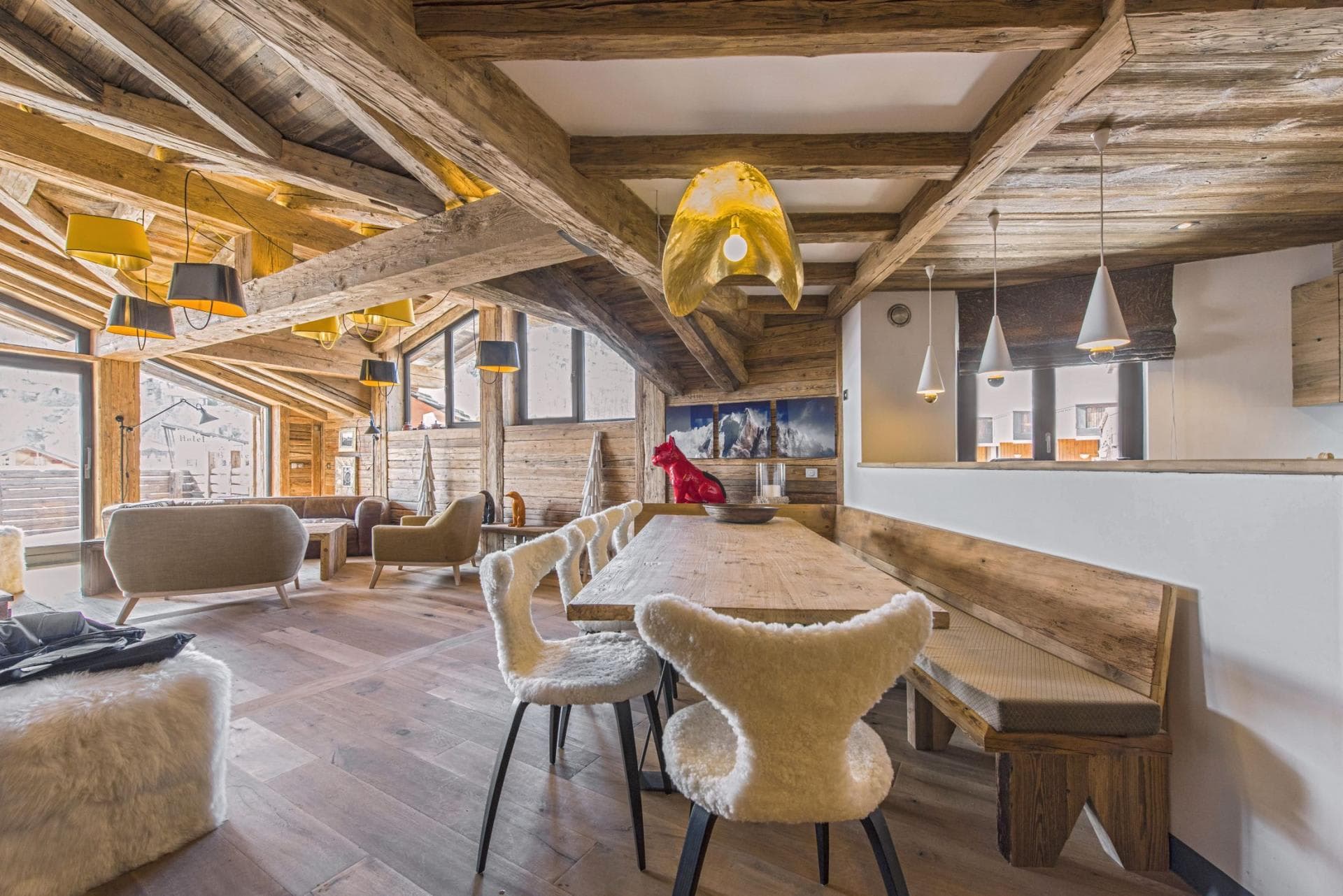 Open-plan dining area with banquet seating and reclaimed wood beams
