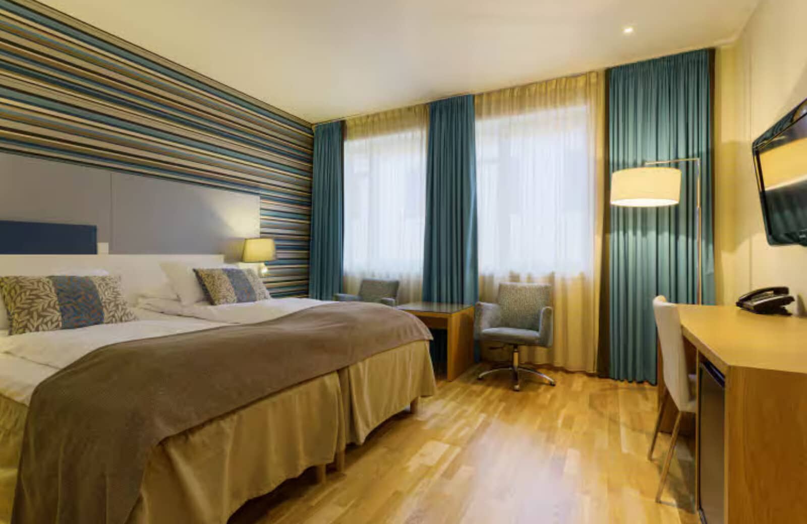 Bedroom with king bed, dedicated workspace, and armchair seating