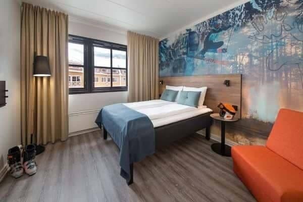 Guest bedroom with queen bed and orange sofa chair