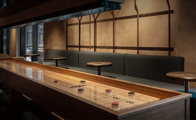 Game room with full-size shuffleboard table and banquette seating