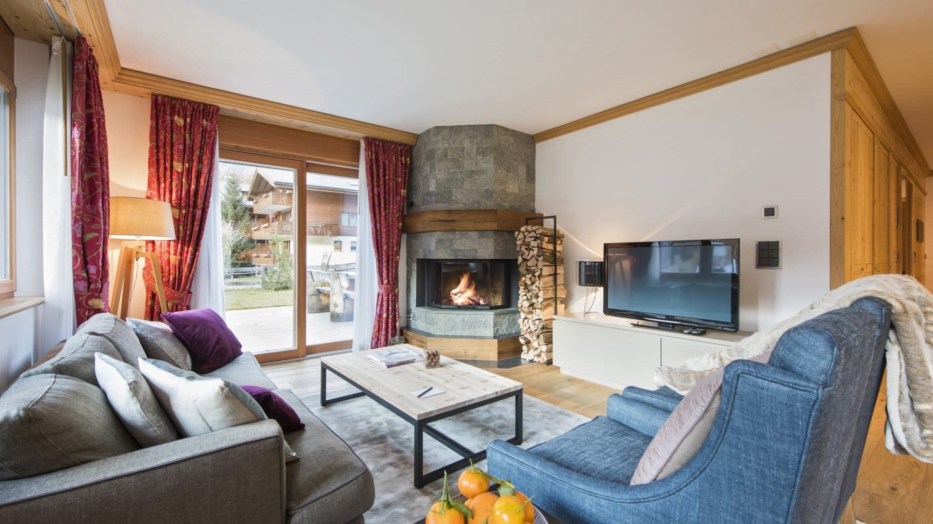 Living area with wood-burning fireplace and sliding door to garden patio