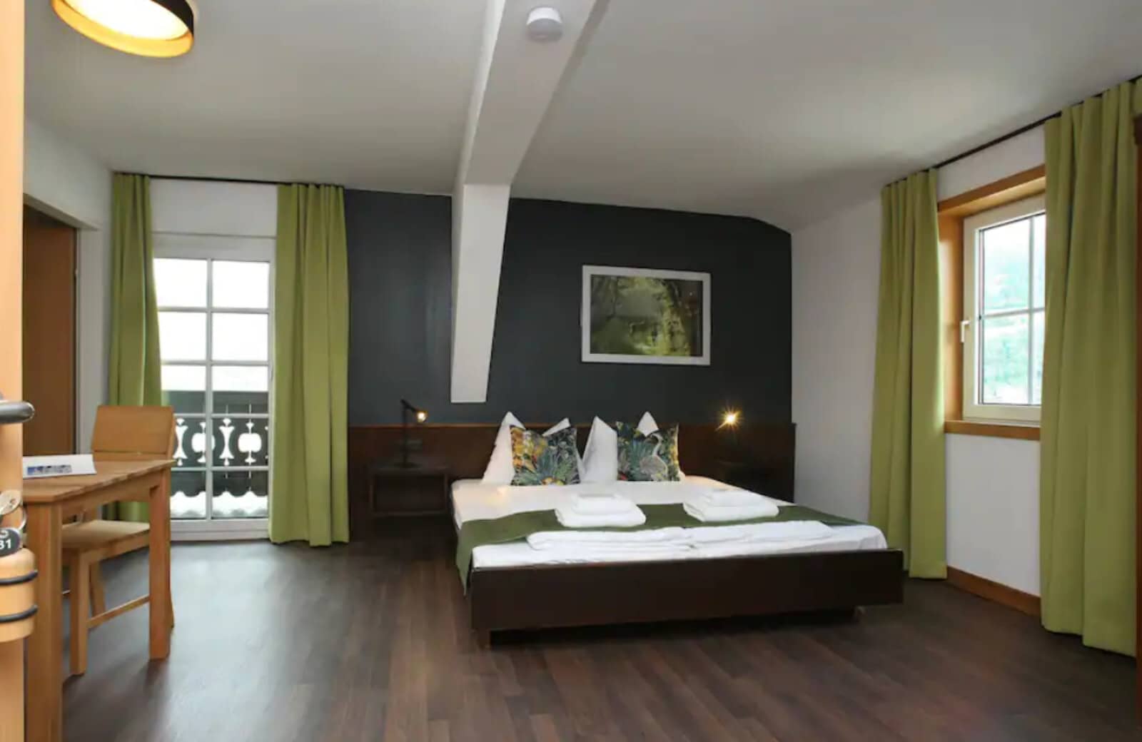 Bedroom with king bed, writing desk, and private balcony access