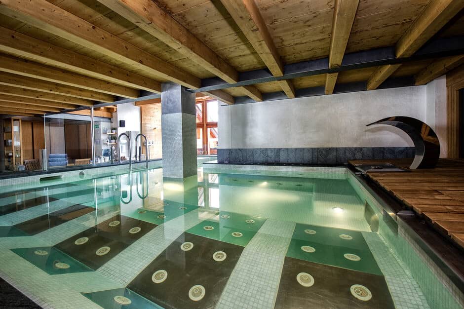 Indoor pool with waterfall feature and submerged massage jets