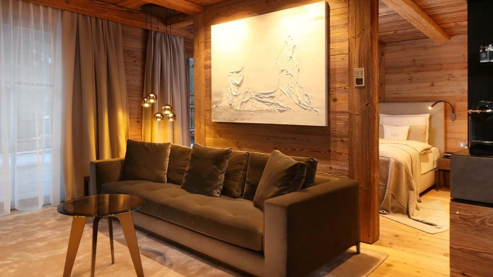 Open-plan suite with velvet sofa, bedroom area, and Nespresso coffee machine