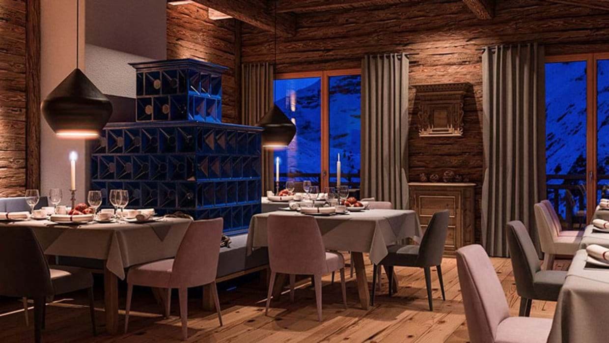 Dining area with traditional blue tiled stove and snowy mountain views