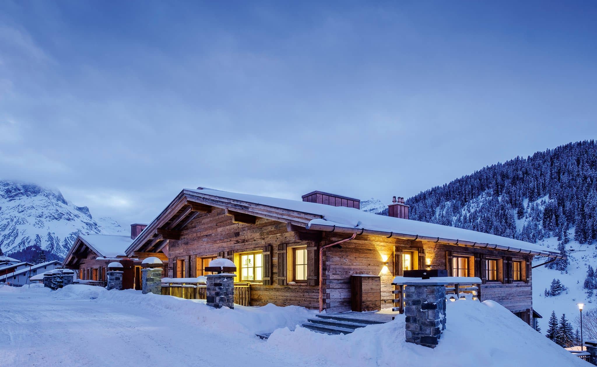 Ski-in chalet exterior with reclaimed wood facade and mountain views